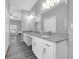 Bathroom featuring double sink granite countertop, storage, and wood look floors at 3956 Shadowind Way, Gotha, FL 34734