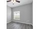 Bedroom with wood look flooring, ceiling fan, and large window at 3956 Shadowind Way, Gotha, FL 34734