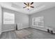 Bedroom featuring a tray ceiling, ceiling fan, and large windows at 3956 Shadowind Way, Gotha, FL 34734