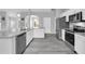 Modern kitchen features stainless steel appliances, granite countertops, and sleek white cabinetry at 3956 Shadowind Way, Gotha, FL 34734