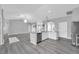 Open concept with kitchen island, stainless appliances, and spacious living area with gray flooring at 3956 Shadowind Way, Gotha, FL 34734