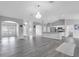 Spacious living space with an open layout, light gray flooring, and modern lighting fixtures at 3956 Shadowind Way, Gotha, FL 34734