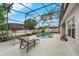 Inviting pool area with a screened enclosure, comfortable seating, and landscaped surroundings at 3956 Shadowind Way, Gotha, FL 34734