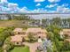 Aerial view of estate home with lush landscaping, a waterfront view, and beautiful surroundings at 11103 Bridge House Rd, Windermere, FL 34786