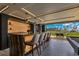 Luxurious home bar with granite countertop, and an unobstructed view to an outdoor living space with beautiful landscaping at 11103 Bridge House Rd, Windermere, FL 34786