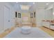 Luxurious bathroom showcasing a tiled tub with marble accents, a chandelier, and a plush white ottoman at 11103 Bridge House Rd, Windermere, FL 34786