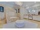 Bathroom featuring a luxurious marble-enclosed tub, vanity, and decorative ottoman at 11103 Bridge House Rd, Windermere, FL 34786