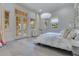 Airy bedroom with large windows, light herringbone floors and double doors leading outside at 11103 Bridge House Rd, Windermere, FL 34786