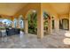 Spacious covered patio with arched openings showcases lush landscaping and tranquil waterfront views at 11103 Bridge House Rd, Windermere, FL 34786