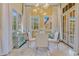 Bright dining room with a glass table, white chairs, and large windows that provide a lovely view at 11103 Bridge House Rd, Windermere, FL 34786