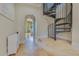 Elegant hallway featuring a spiral staircase, tile floors, and an arched doorway at 11103 Bridge House Rd, Windermere, FL 34786