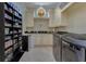 Well-organized laundry room with custom shelving, a charming window, and modern washer and dryer units at 11103 Bridge House Rd, Windermere, FL 34786