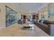 Elegant living room with a custom wine cellar, travertine floors, and an oversized gray sectional sofa at 11103 Bridge House Rd, Windermere, FL 34786