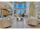 Elegant living room with a fireplace, grand piano, and large windows offering scenic views at 11103 Bridge House Rd, Windermere, FL 34786