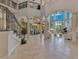 Expansive living room featuring high ceilings, travertine floors, and a staircase with wrought iron railing at 11103 Bridge House Rd, Windermere, FL 34786