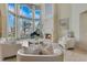 Elegant living room with soaring ceilings, fireplace, piano, and stunning lake views through expansive windows at 11103 Bridge House Rd, Windermere, FL 34786