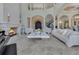 Grand living room featuring a soaring ceiling, fireplace, staircase, and luxurious finishes throughout at 11103 Bridge House Rd, Windermere, FL 34786