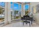 Elegant living area featuring lake views and a grand piano at 11103 Bridge House Rd, Windermere, FL 34786