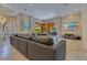 Expansive living room with a large gray sofa, travertine flooring, and access to the outdoor living area at 11103 Bridge House Rd, Windermere, FL 34786