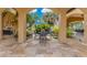 Relaxing patio with a dining area, framed by lush landscaping and architectural arches at 11103 Bridge House Rd, Windermere, FL 34786