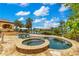 Resort-style pool and spa with travertine patio, sun loungers, and umbrellas offer a relaxing outdoor oasis at 11103 Bridge House Rd, Windermere, FL 34786
