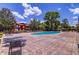 Resort-style pool with brick patio surrounded by lush landscaping and lounge chairs at 114 Vista Verdi Cir # 116, Lake Mary, FL 32746