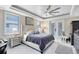 Bright bedroom with tray ceiling, fan, and large windows at 1154 Kerwood Cir, Oviedo, FL 32765