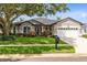 Charming single-story home with a well-manicured lawn and mature landscaping at 1154 Kerwood Cir, Oviedo, FL 32765