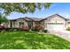 Charming single-story home with a well-manicured lawn and mature landscaping at 1154 Kerwood Cir, Oviedo, FL 32765
