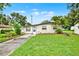 Single-story home boasting a well-manicured lawn, palm trees, and a walkway to the front door at 1170 E Bay St, Winter Garden, FL 34787