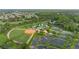 Aerial view of community amenities, including a baseball field, ponds, tennis courts, and clubhouse at 118 Ventana Dr, Kissimmee, FL 34759