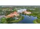 Community aerial view featuring a tranquil lake, pool, terracotta rooftops, and lush landscape at 118 Ventana Dr, Kissimmee, FL 34759