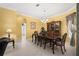 Formal dining room features bright yellow walls, elegant chandelier, and classic wood furniture at 118 Ventana Dr, Kissimmee, FL 34759
