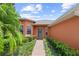 Inviting front entrance with a brick pathway, lush greenery, and vibrant exterior paint at 118 Ventana Dr, Kissimmee, FL 34759