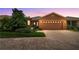 Charming home featuring a brick driveway, two-car garage, and lush landscaping creating great curb appeal at 118 Ventana Dr, Kissimmee, FL 34759