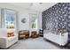Charming Bedroom with a cozy rocking chair, crib, and playful wallpaper at 13334 Beebe Aly, Orlando, FL 32827