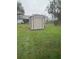 Exterior view of backyard storage shed surrounded by a green grass lawn at 1335 Cr 442, Lake Panasoffkee, FL 33538