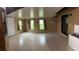 Large sunroom with a white door, a ceiling, three windows, and an air conditioner unit at 1335 Cr 442, Lake Panasoffkee, FL 33538