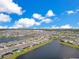 Expansive aerial shot of a community with numerous homes, multiple lakes, and a picturesque blue sky at 13461 Panama Beach Ct, Orlando, FL 32827