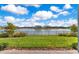 Lush backyard has a metal fence and a scenic lake view, creating a peaceful outdoor space at 13461 Panama Beach Ct, Orlando, FL 32827