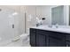 Bright bathroom features a glass shower, a modern vanity with white countertops, and dark cabinets at 13461 Panama Beach Ct, Orlando, FL 32827