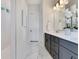Bright bathroom with grey cabinets, marble floors, and a large vanity mirror at 13461 Panama Beach Ct, Orlando, FL 32827