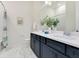 Modern bathroom featuring double sinks, white countertops, and blue cabinets with stylish fixtures at 13461 Panama Beach Ct, Orlando, FL 32827