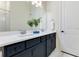 Elegant bathroom with double sinks, navy blue cabinetry, white countertops and modern fixtures at 13461 Panama Beach Ct, Orlando, FL 32827