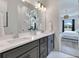 Bathroom featuring double sinks, grey cabinets, and marble floors that lead to the bedroom at 13461 Panama Beach Ct, Orlando, FL 32827