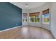 Bright bedroom features hardwood floors, blue accent wall, and three windows with woven shades at 13461 Panama Beach Ct, Orlando, FL 32827
