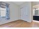 Bedroom featuring hardwood floors, closet with sliding doors, and blue patterned curtains at 13461 Panama Beach Ct, Orlando, FL 32827