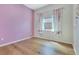 Bright bedroom with hardwood floors, a pink accent wall, and floral curtains providing a cozy feel at 13461 Panama Beach Ct, Orlando, FL 32827