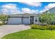 Charming home showcasing a three-car garage, paved driveway, and well-manicured lawn at 13461 Panama Beach Ct, Orlando, FL 32827