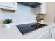 Modern kitchen features a smooth cooktop with white cabinets and quartz countertops at 13461 Panama Beach Ct, Orlando, FL 32827